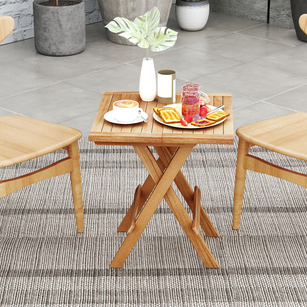 Patio folding side table with slatted teak wood top and X-shaped legs, perfect for outdoor dining and picnics.