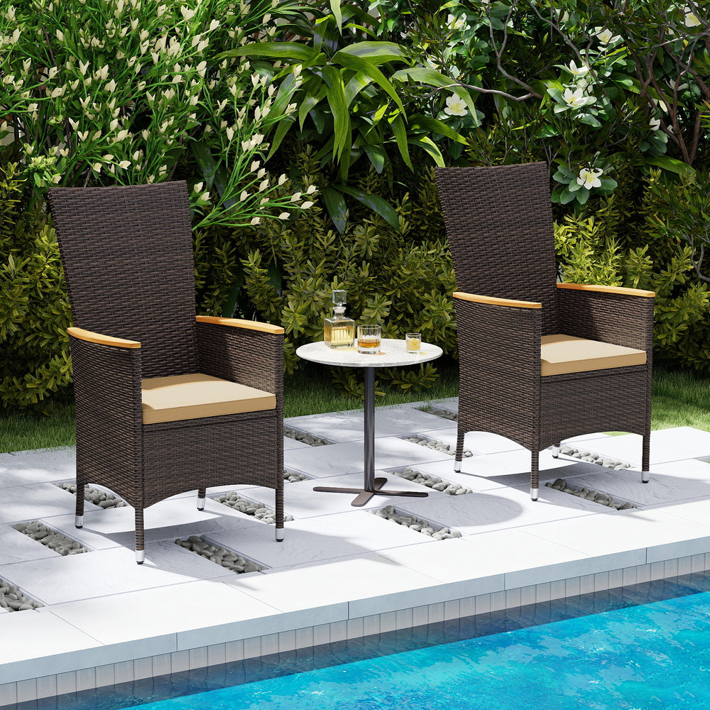 Two outdoor wicker dining chairs with high backrests and beige cushions, placed poolside for stylish relaxation.