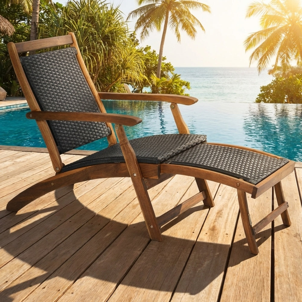 Patio rattan folding lounge chair with acacia wood frame, featuring a retractable footrest, perfect for poolside.