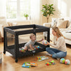 Portable black baby playard with mesh sides and soft mattress, perfect for safe play and sleep in any room.