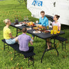 Portable folding camping table with a large black tabletop, set up for a picnic, accommodating food and drinks.
