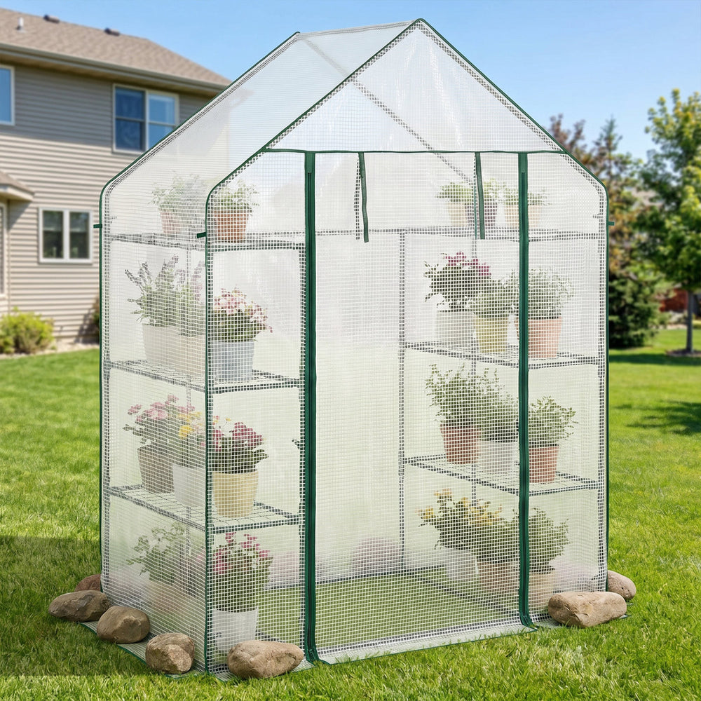 Portable walk-in greenhouse with 3 tiers and 6 shelves, featuring a white cover and potted plants for gardening.