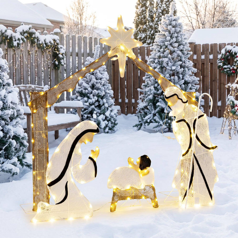 Pre-lit artificial crystal Holy Family decoration with warm white LED lights, star top, and door design in a snowy yard.
