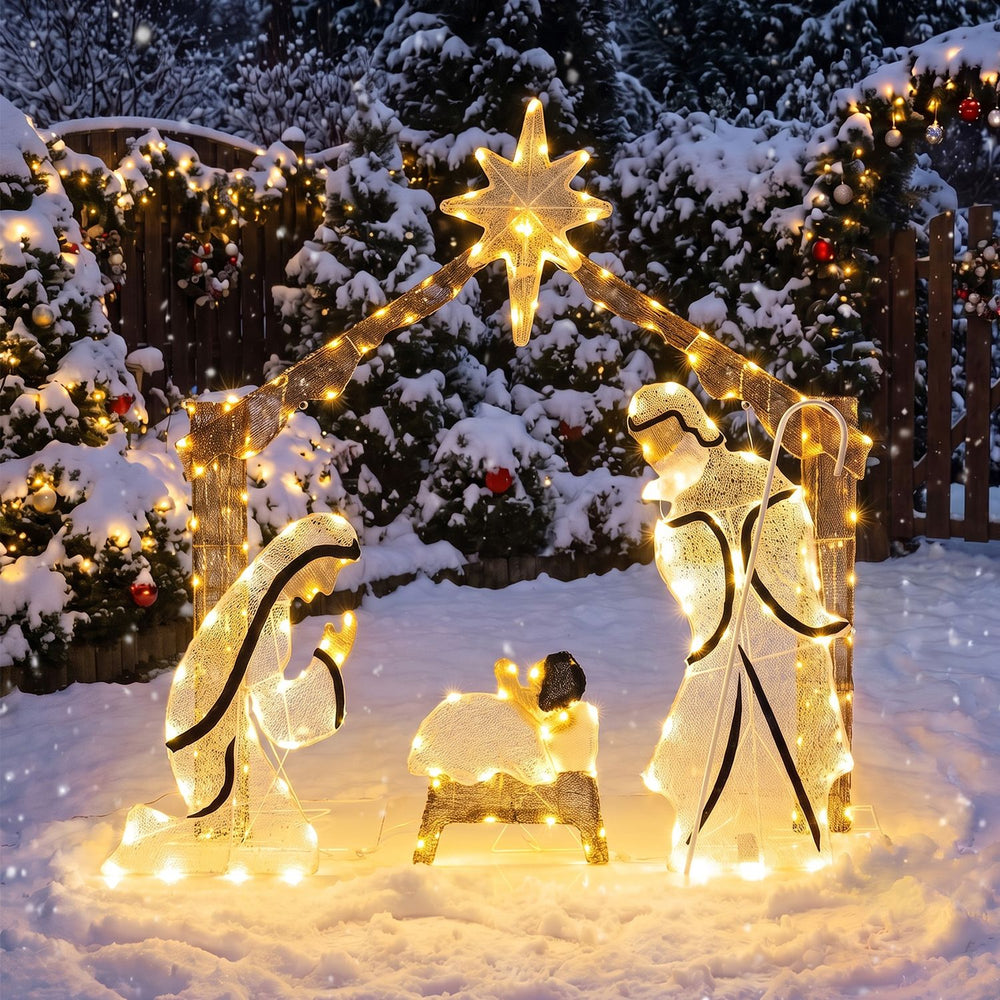 Pre-lit artificial crystal Holy Family decoration with warm white LED lights, top star, and door design in a snowy yard.