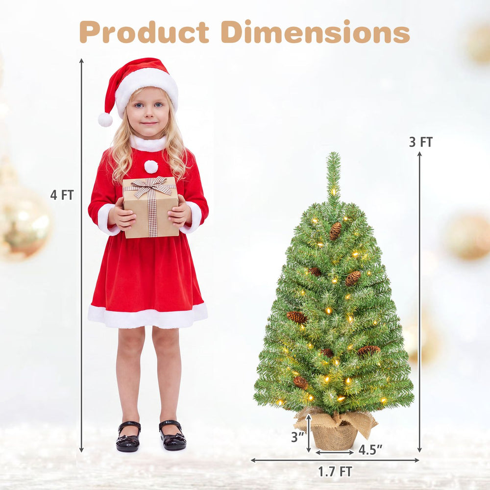 3 ft pre-lit mini Christmas tree with 50 warm white LED lights and pine cones, shown beside a child for scale.