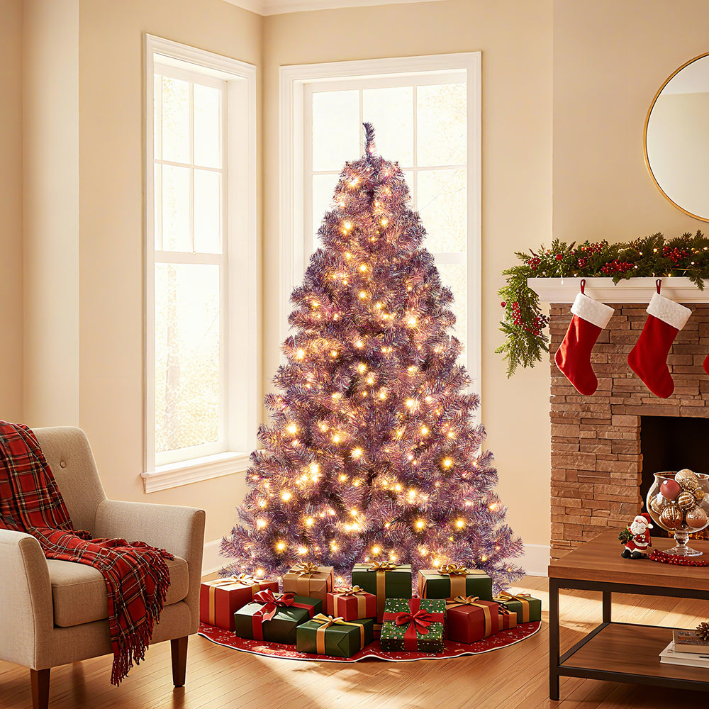 Pre-lit 6ft tinsel Christmas tree in deep purple with warm white LED lights, surrounded by colorful wrapped gifts.