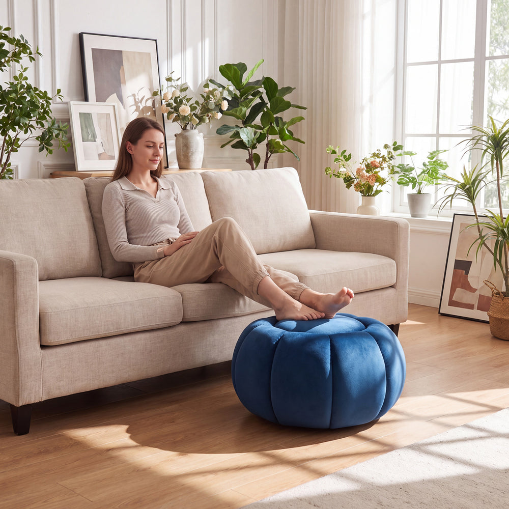 Blue pumpkin ottoman with hidden storage and removable lid, featuring a soft velvet surface for comfortable foot resting.