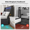 Wide wingback headboard of a queen size upholstered platform bed frame in grey with built-in LED lights and charging.
