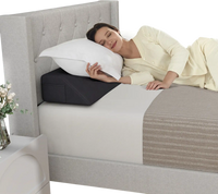 Bed wedge pillow in use, providing spinal support and filling gaps, with side storage pockets for essentials.