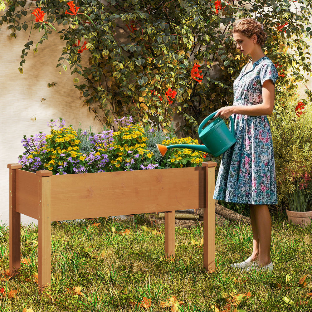 Raised garden bed with legs and drainage holes, featuring a natural wood frame, ideal for flowers and herbs in the.
