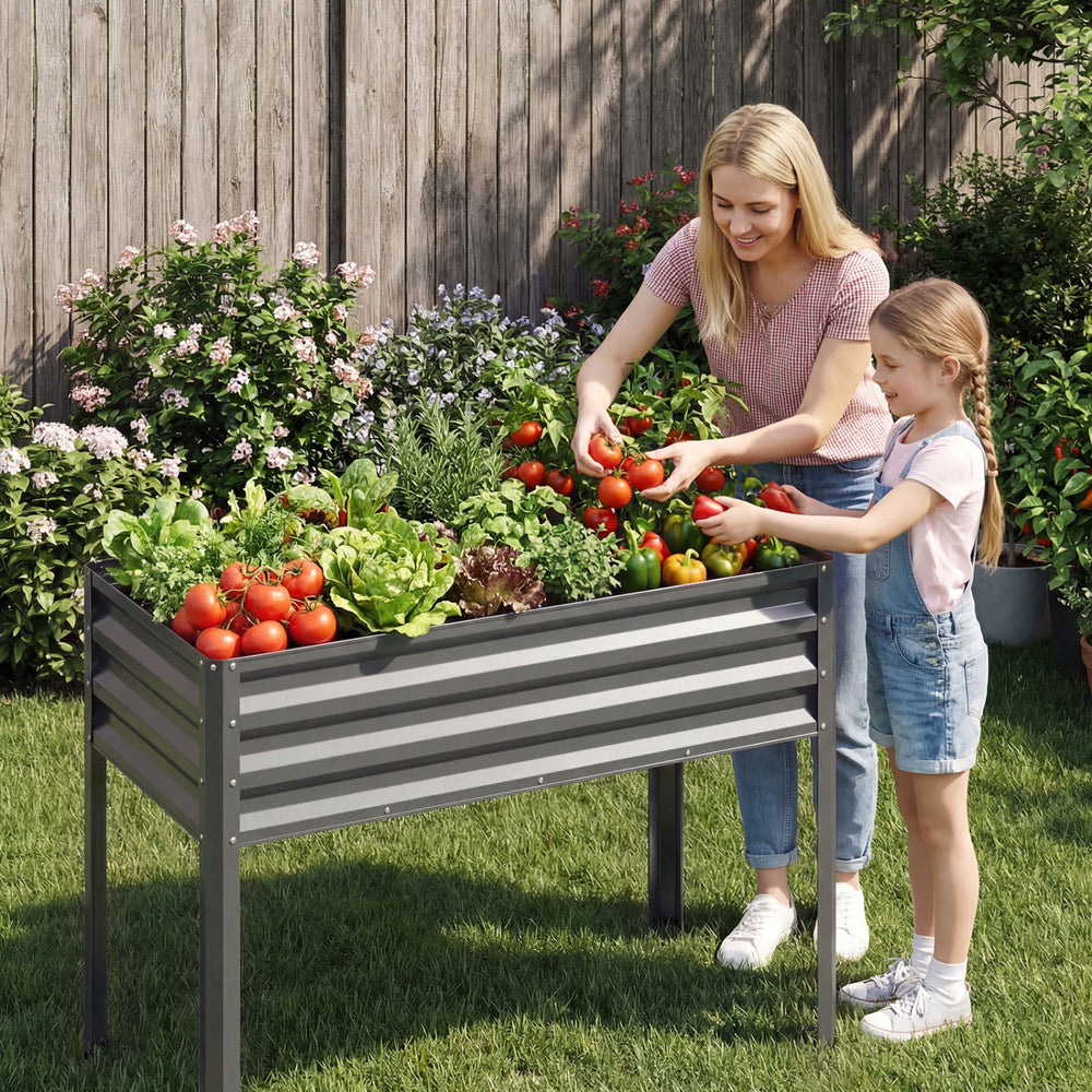 Large elevated planter box in grey, featuring a mother and daughter harvesting fresh vegetables in a garden setting.