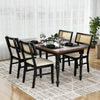 Black rattan dining chairs with padded seats, featuring rubber wood legs, arranged around a dining table for a stylish.