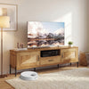 Natural rattan TV stand for TVs up to 80", featuring two cabinets and an open shelf for organized storage.