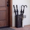 Rectangular black umbrella holder rack with removable drip tray, stylishly organizing umbrellas by the door.
