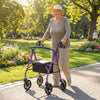 Purple rollator walker with seat, adjustable handles, and storage bag, perfect for outdoor use and resting.