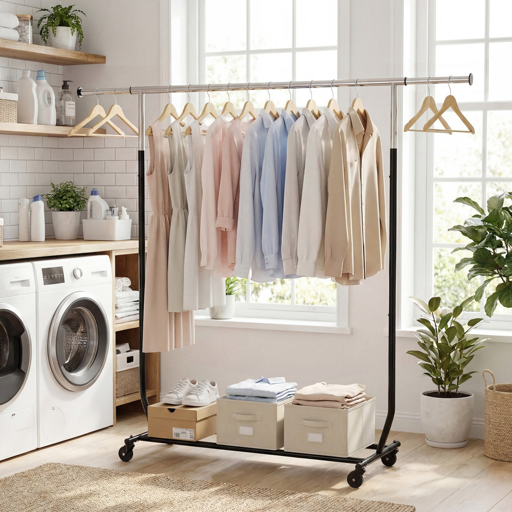 Extendable rolling clothes rack with hanging shirts and storage bins, ideal for laundry or bedroom organization.