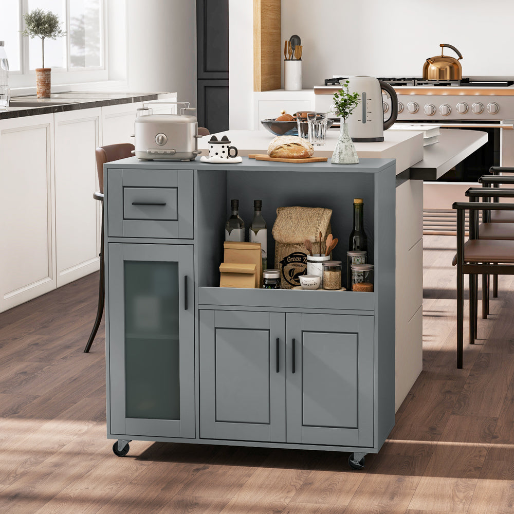 Gray rolling kitchen island with wheels, featuring a drawer, glass door cabinet, and spacious tabletop for culinary use.