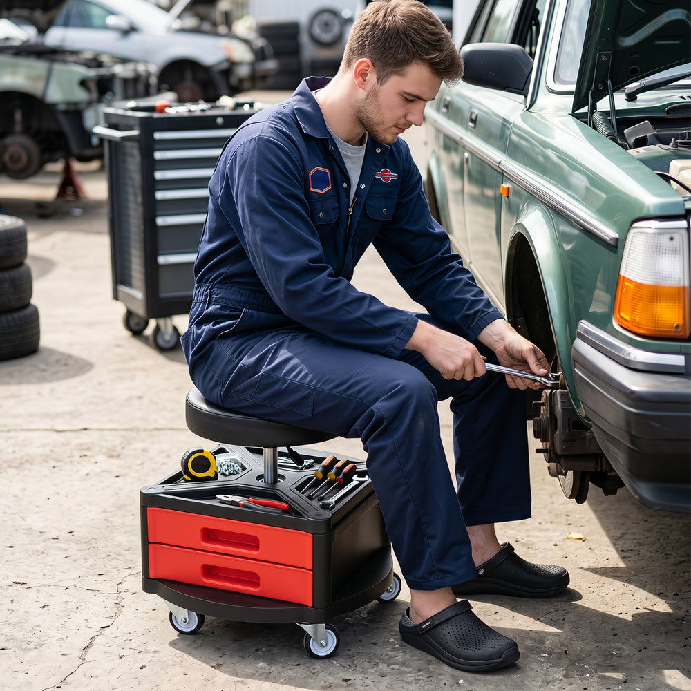 Rolling mechanic stool with cushioned seat, dual tool trays, and adjustable height for garage and repair shop use.