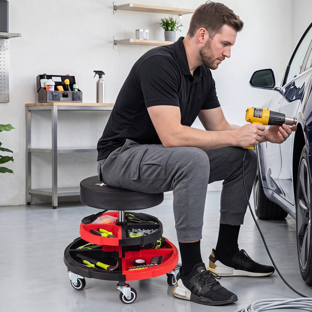 Rolling mechanic stool with cushioned seat, adjustable height, and 5 wheels, ideal for garages and repair shops.