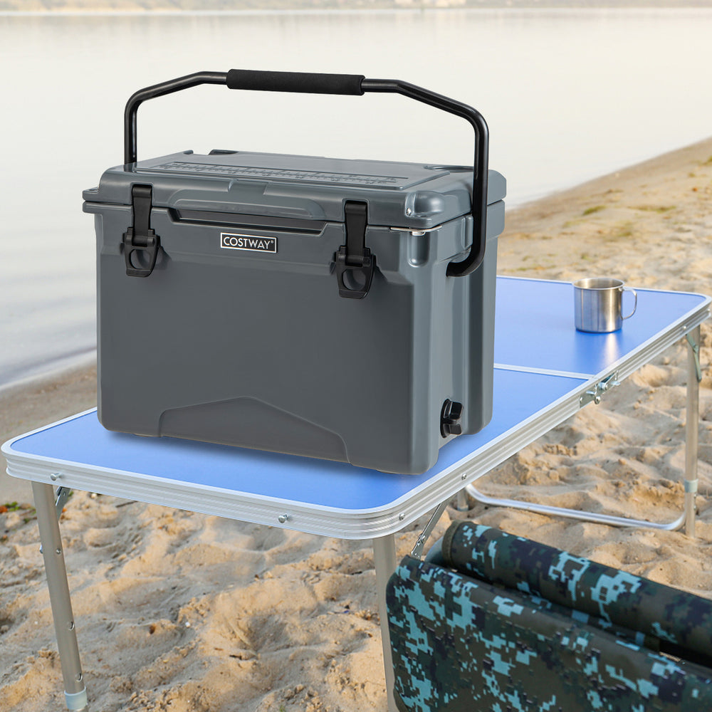 25 QT gray hard cooler with aluminum handle and integrated cup holders on a camping table by the water.