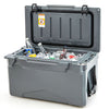 Gray rotomolded cooler with integrated cup holders, filled with ice and drinks, ideal for camping and outdoor use.