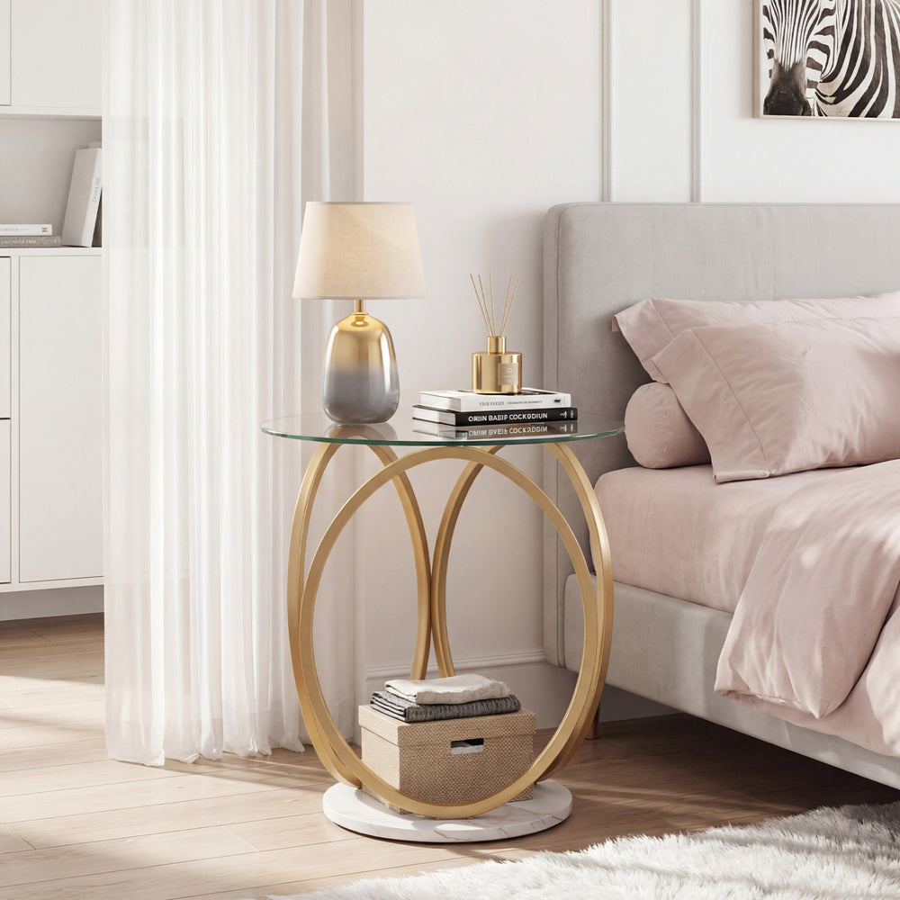 Round end table with tempered glass top and faux marble base, featuring a gold metal frame for modern bedroom decor.