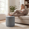 Round gray storage ottoman with removable lid, acacia wood frame, and soft chenille fabric for versatile use.