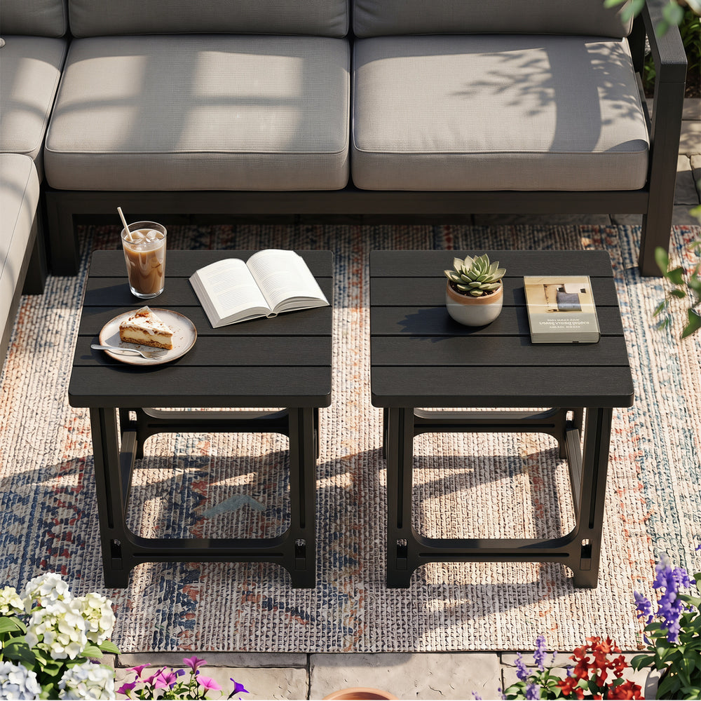 Set of 2 black outdoor Adirondack side tables with slatted surfaces, perfect for poolside use and low-maintenance enjoyment.