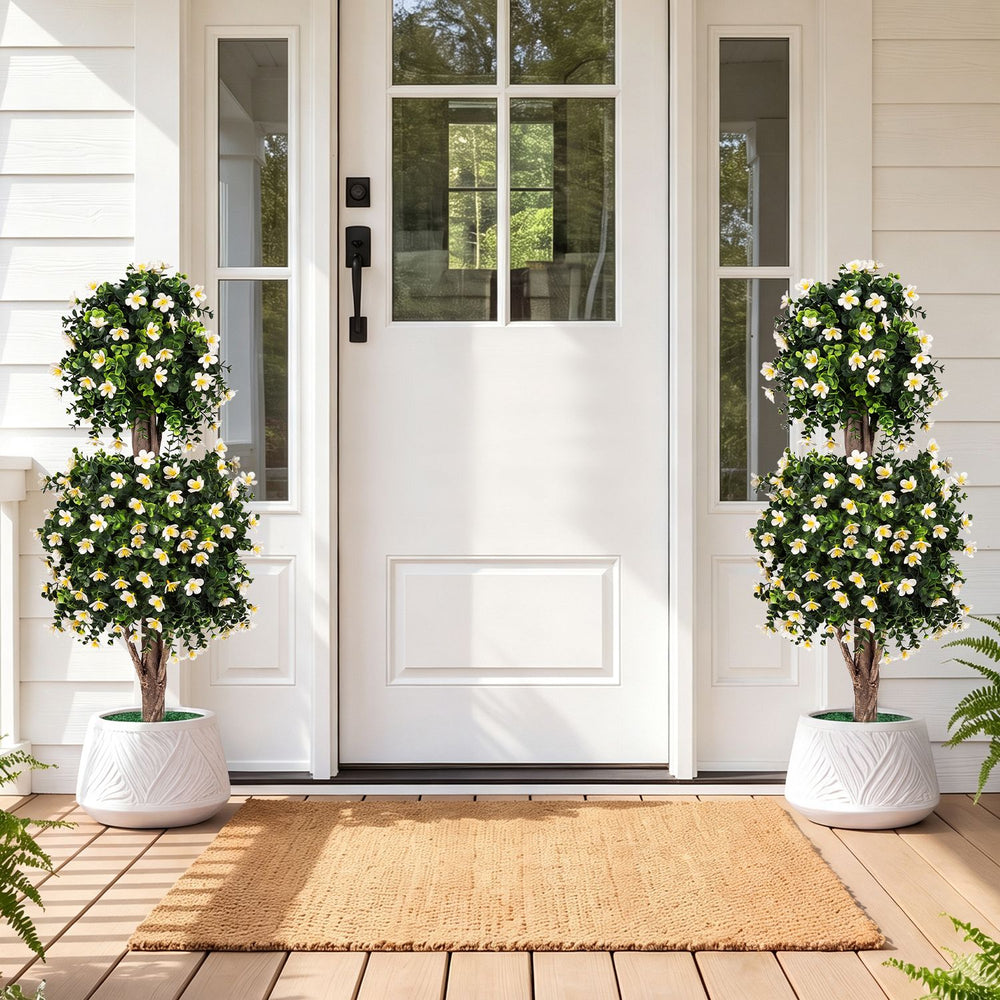 Set of 2 artificial topiary trees with white blossoms in weighted pots, perfect for enhancing front porches or indoor spaces.