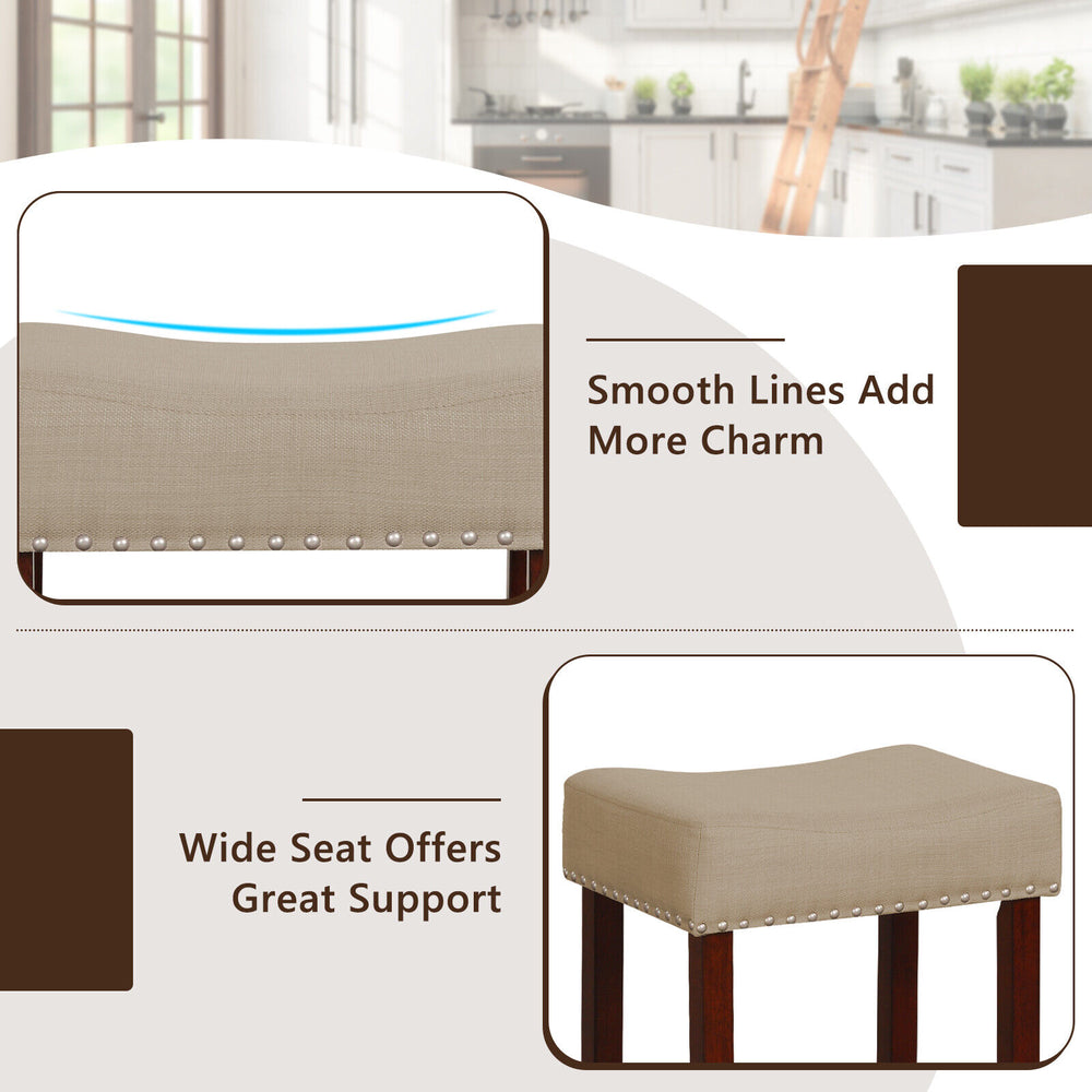 Beige upholstered bar stool with solid rubber wood legs, featuring a wide seat and nailhead trim for stylish support.
