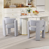 Gray upholstered armchairs with curved backrests and thick cushions, ideal for dining or living room settings.