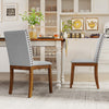 Upholstered dining chairs with padded seats and walnut legs, featuring decorative nailhead trim for elegant dining.