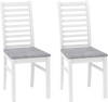 Set of 2 white wooden dining chairs with rubber wood legs and grey padded seats, perfect for dining rooms or cafes.