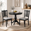 Two black wooden dining chairs with soft-padded cushions and ergonomic hollow backs, perfect for farmhouse-style dining.