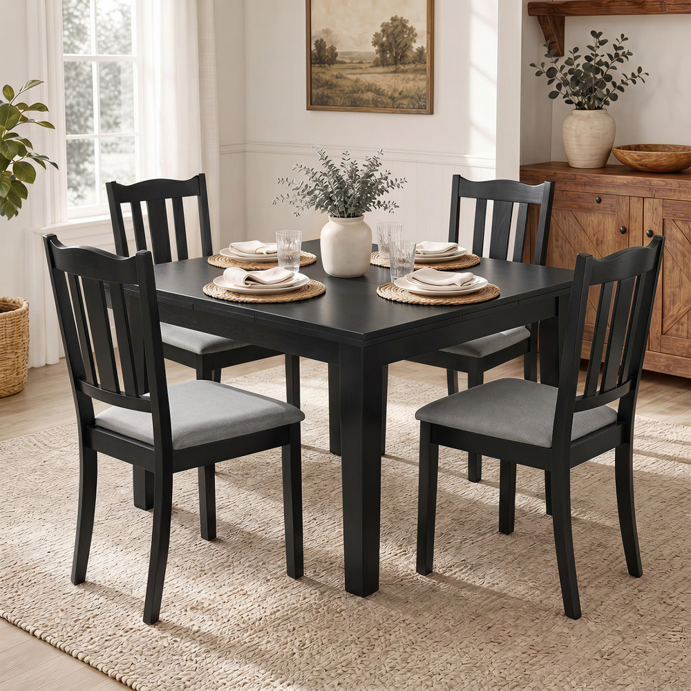 Set of 4 black wooden dining chairs with soft-padded cushions and ergonomic hollow backs for comfortable seating.