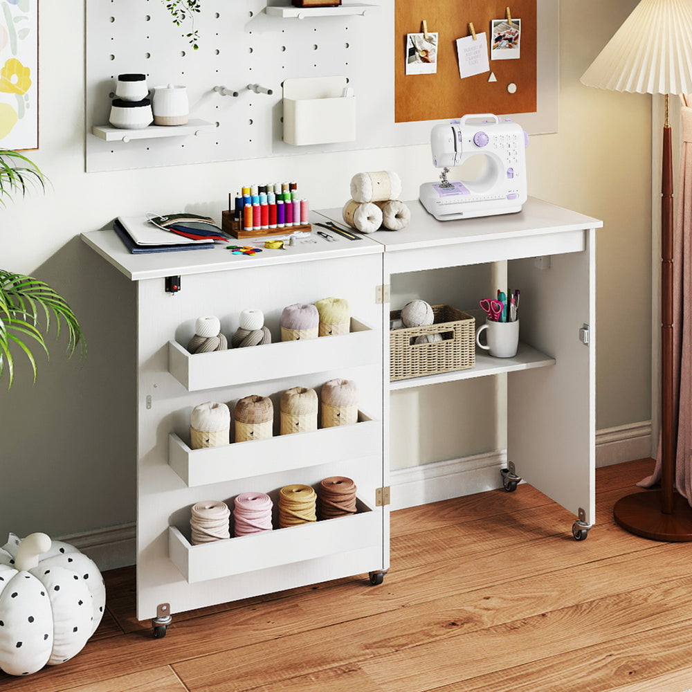 Sewing machine table in white with lockable casters, featuring a 3-tier shelf and built-in charging station for.