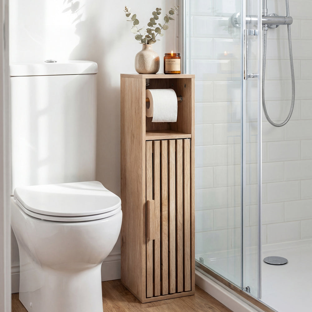 Freestanding natural wood bathroom cabinet with toilet paper holder, slat design, and hidden storage for toiletries.