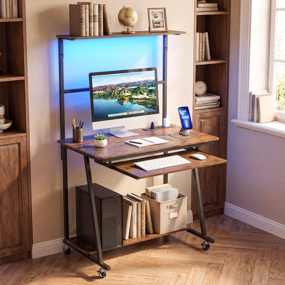 Small computer desk in rustic brown with LED lights, charging station, and wheels for easy mobility in compact spaces.