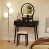 Small black vanity makeup dressing table set with cushioned stool and LED lighted mirror, ideal for compact bedrooms.