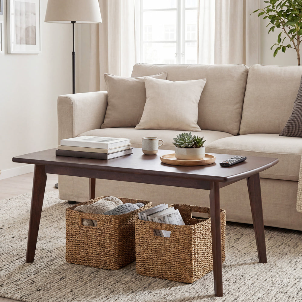 Solid wood modern coffee table with tapered legs in walnut finish, featuring a wide tabletop and unique wood grain.