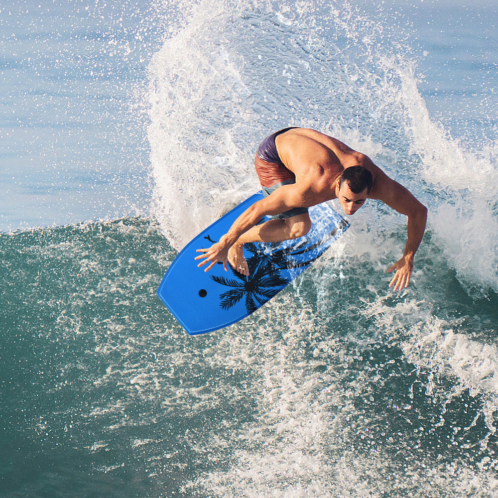 Surfer riding a wave on a blue Super Lightweight Bodyboard with palm design, ideal for outdoor water sports.