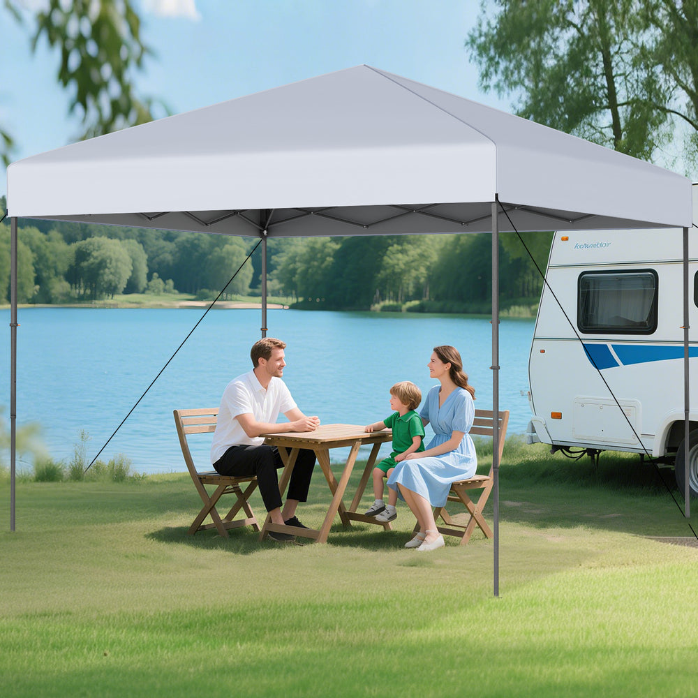 Pop-up canopy tent set up by a lake, featuring a white oxford canopy for sun protection and easy portability.