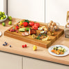 Extra large 24" teak wood cutting board with handle, featuring vibrant fresh ingredients for versatile kitchen use.