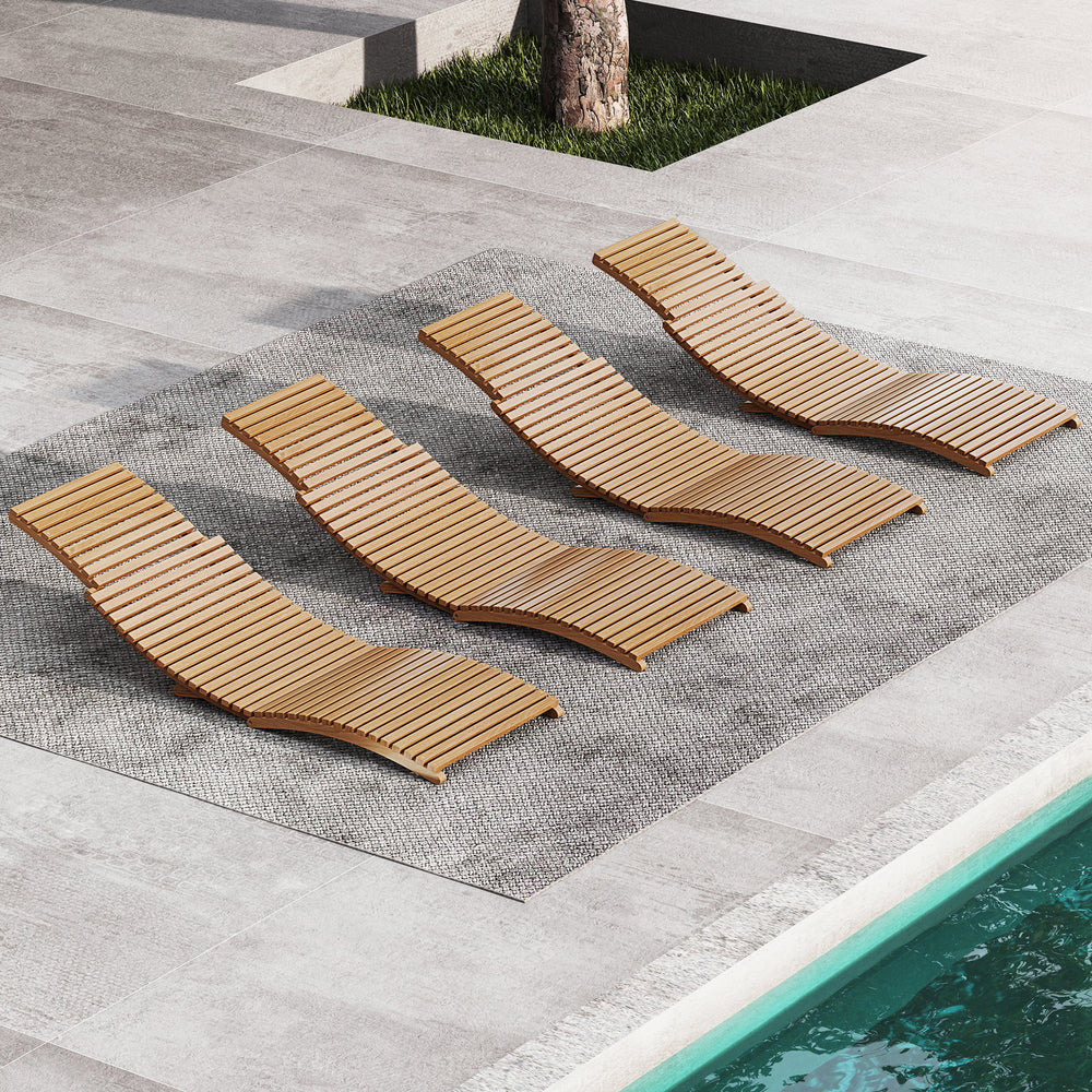 Four teak wood patio folding chaise lounge chairs arranged poolside, featuring slatted seats for outdoor relaxation.