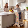 Toddler standing tower step stool with adjustable height, chalkboard, and fun toys for kitchen activities and play.