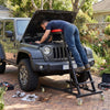 Topside automotive engine creeper in use, featuring a sturdy metal frame and adjustable height for vehicle maintenance.