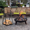 Triangle firewood rack in black with raised base, holding logs for outdoor fire pit, sturdy steel frame for stability.
