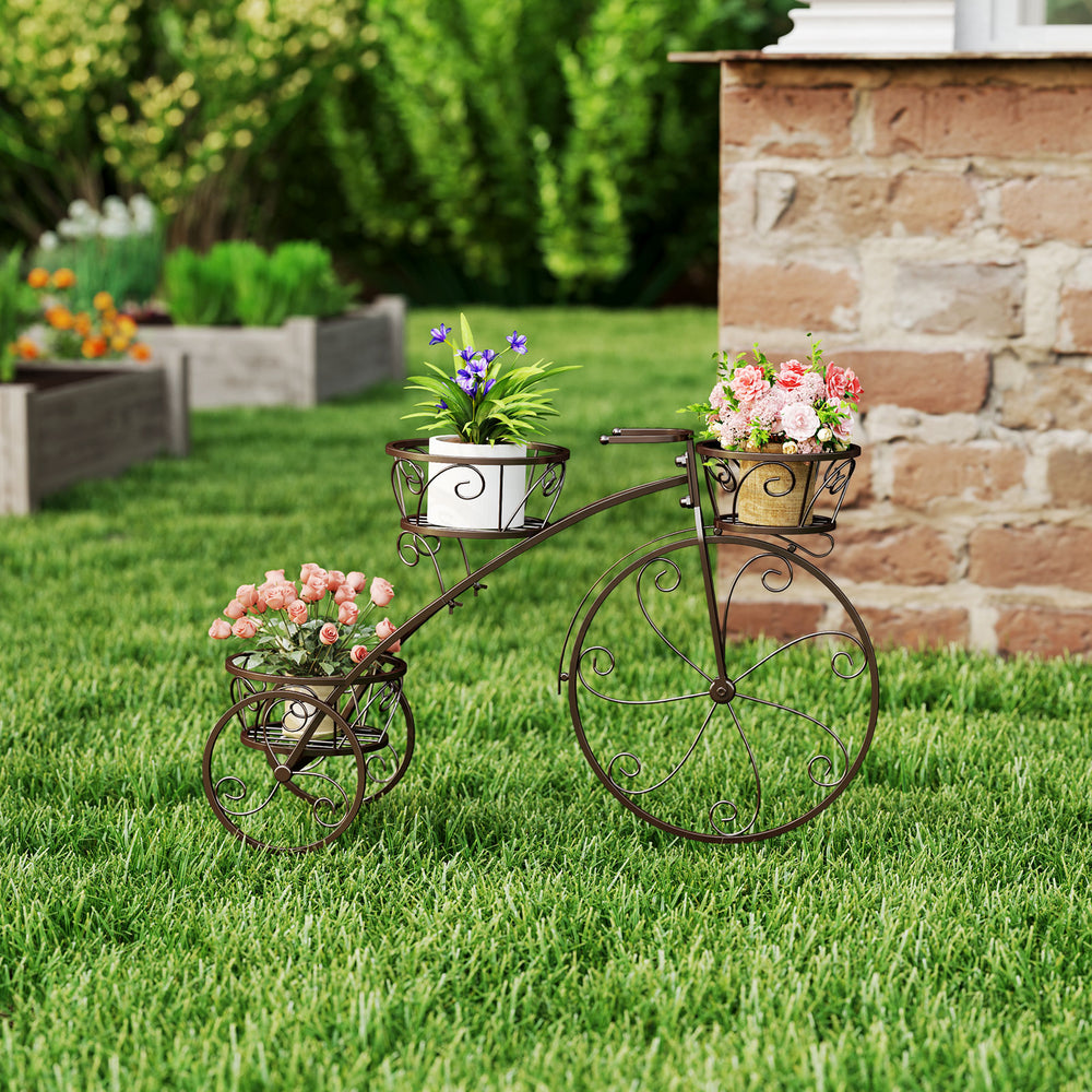 Tricycle plant stand in bronze with three hollowed baskets, ideal for indoor or outdoor floral display.