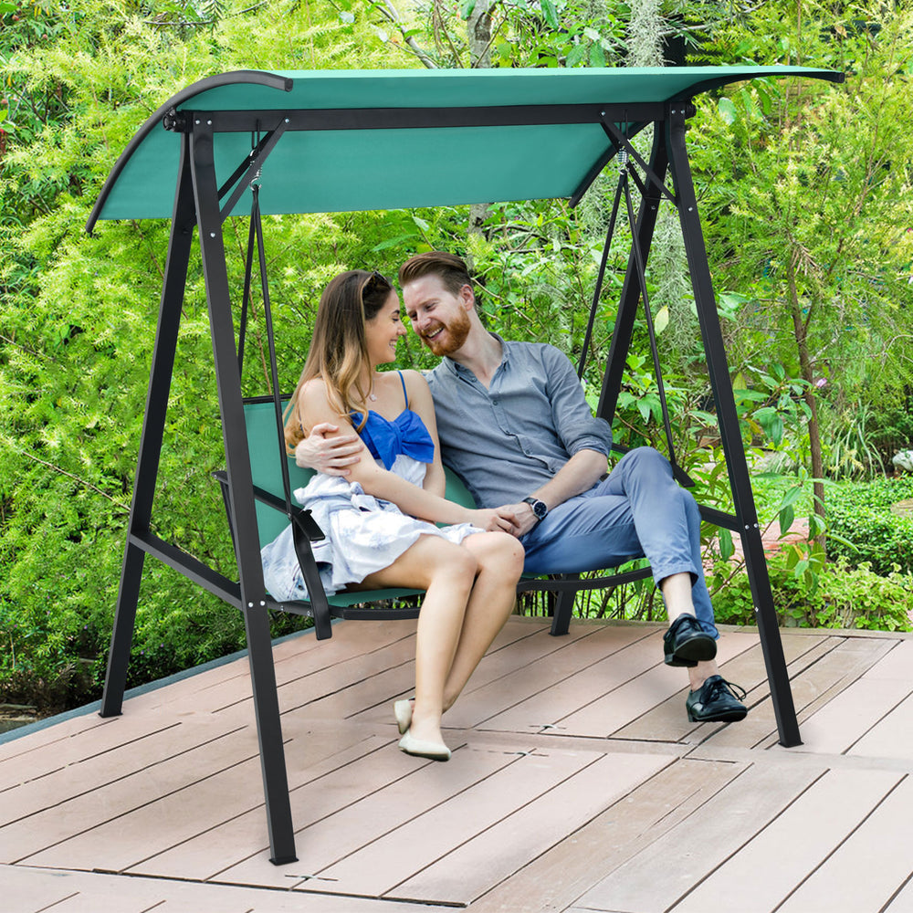 Two-person patio swing with adjustable green canopy, sturdy steel frame, perfect for garden or balcony relaxation.
