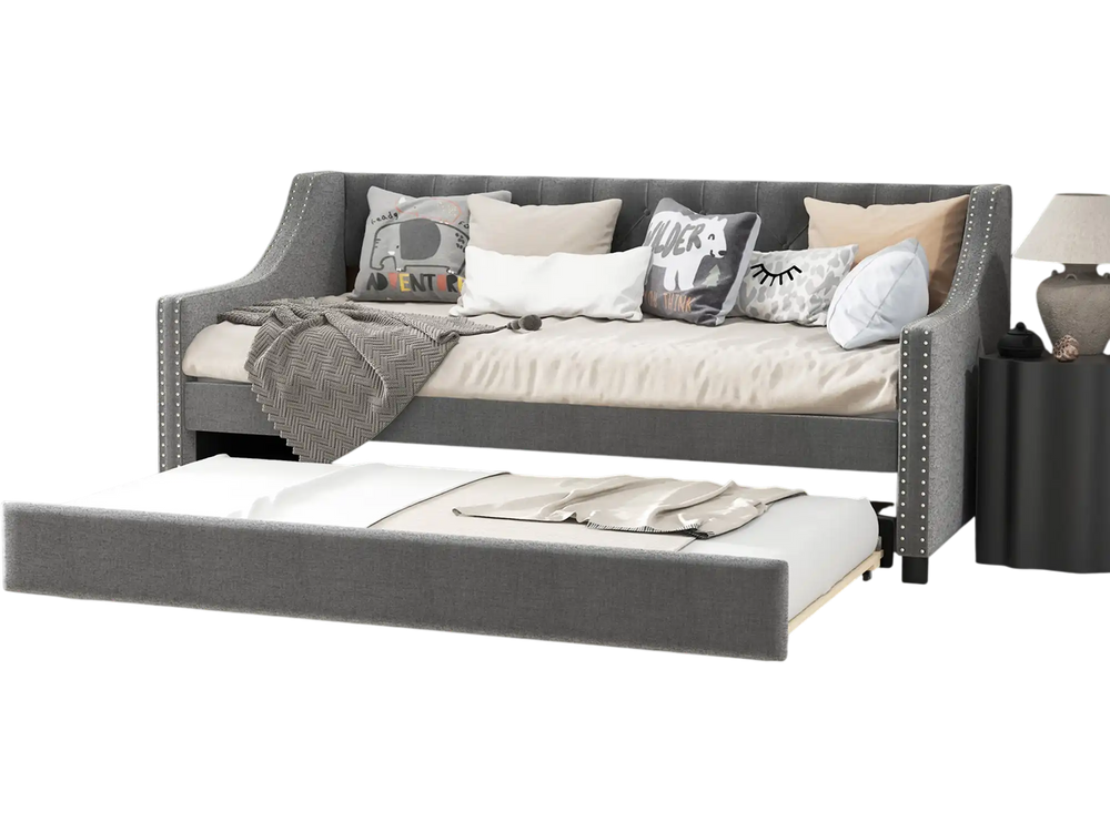 Twin size gray daybed with trundle, curved armrests, and soft cushions, perfect for space-saving guest sleeping.